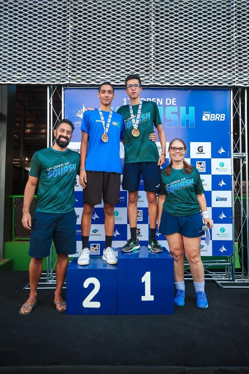 Um grupo de pessoas está em um pódio com medalhas.