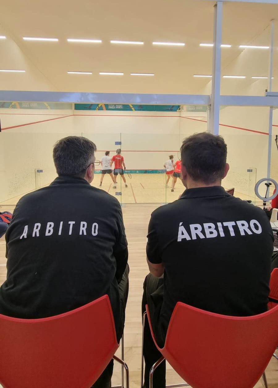 Dois homens sentados em cadeiras com a palavra arbitro nas costas