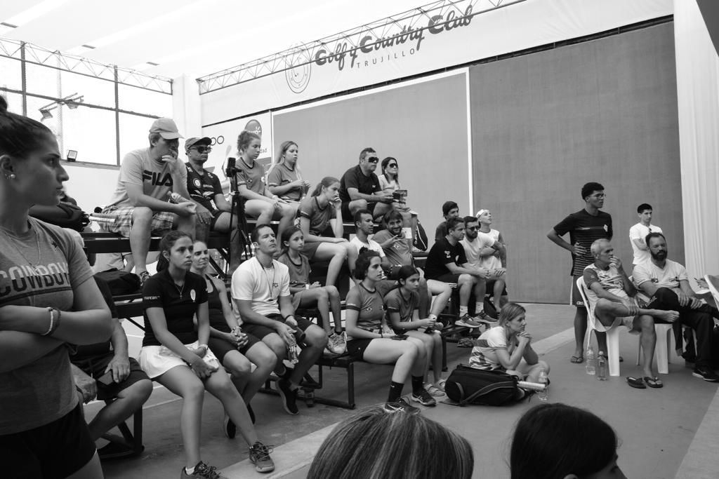 Uma foto em preto e branco de um grupo de pessoas sentadas em bancos.