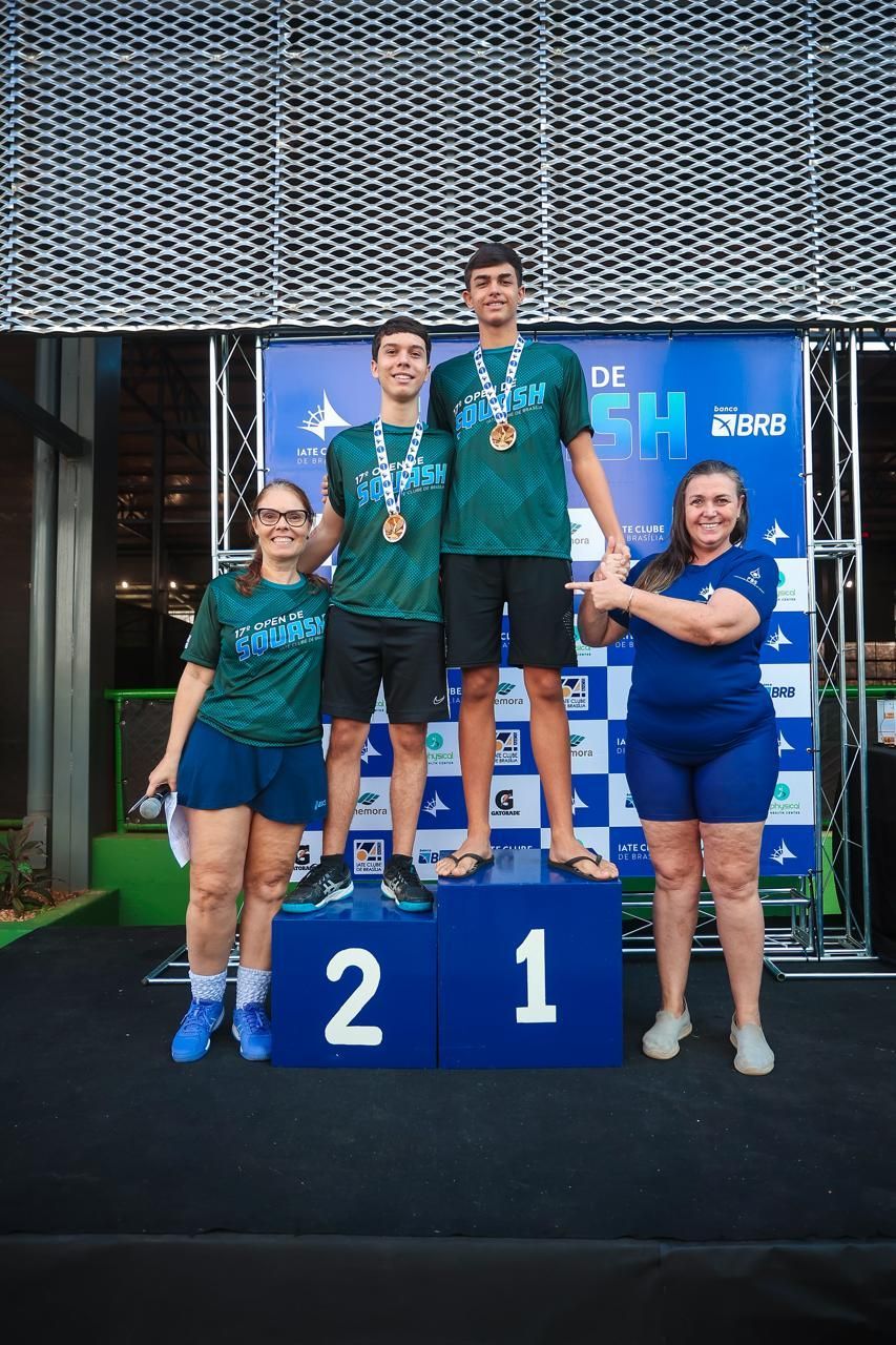 Um grupo de pessoas em pé no topo de um pódio com o número 2 nele.