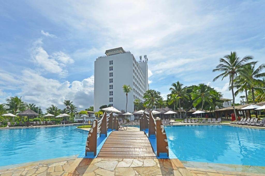 Um grande edifício branco está atrás de uma grande piscina