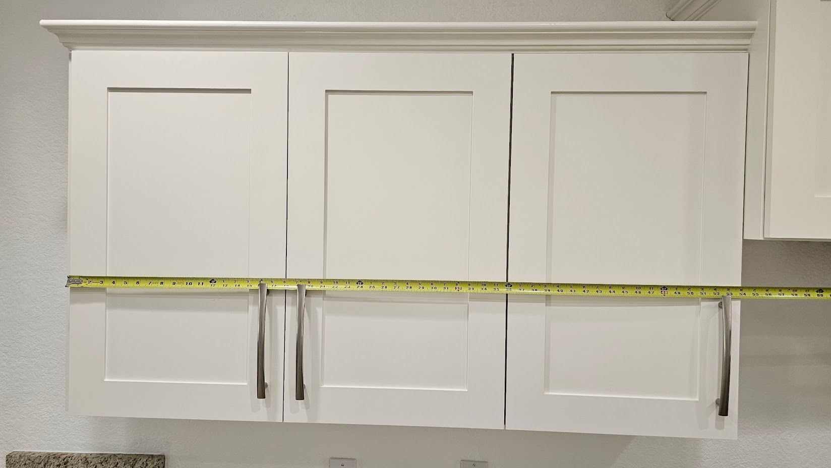 A measuring tape is being used to measure the height of a cabinet