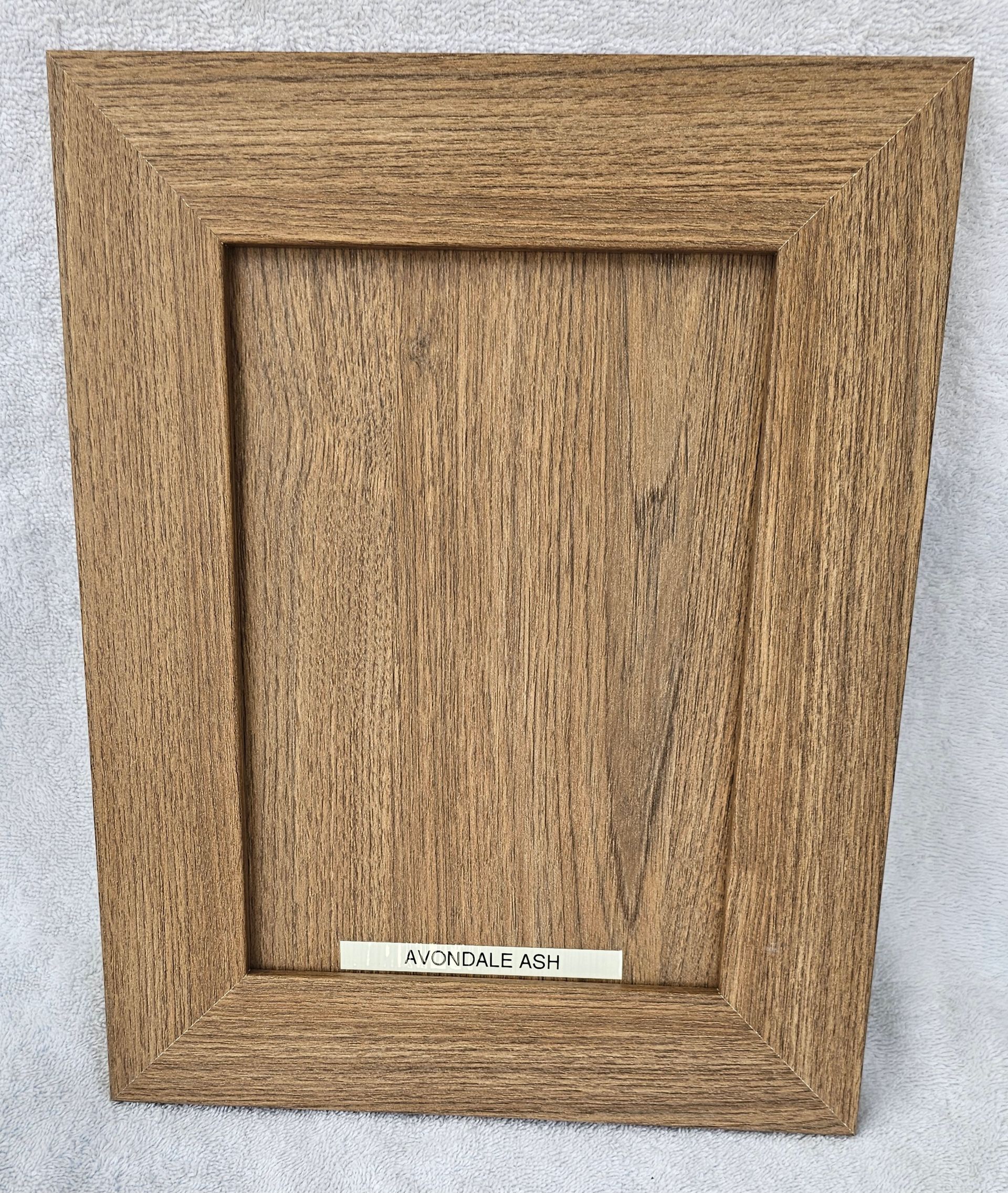 A wooden picture frame with a tag that says ' t.e.a. ' on it