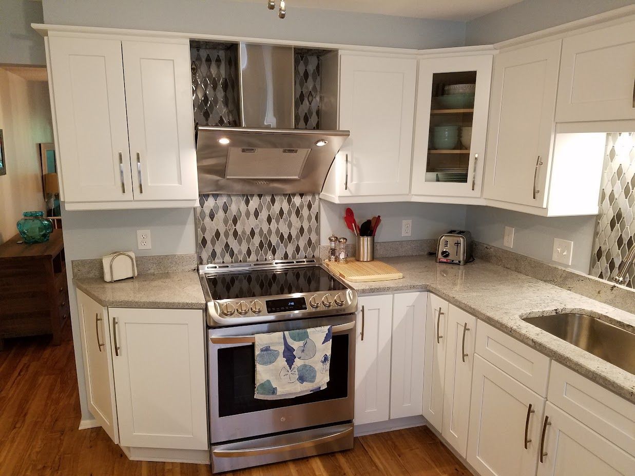 A kitchen with white cabinets and stainless steel appliances.