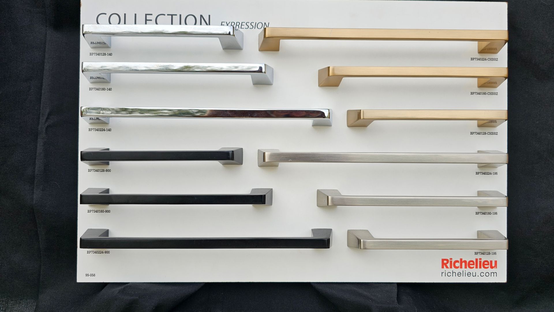 A collection of cabinet handles is displayed on a white board