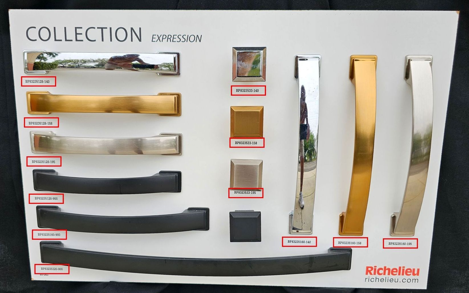 A collection of kitchen cabinet handles is displayed on a white board