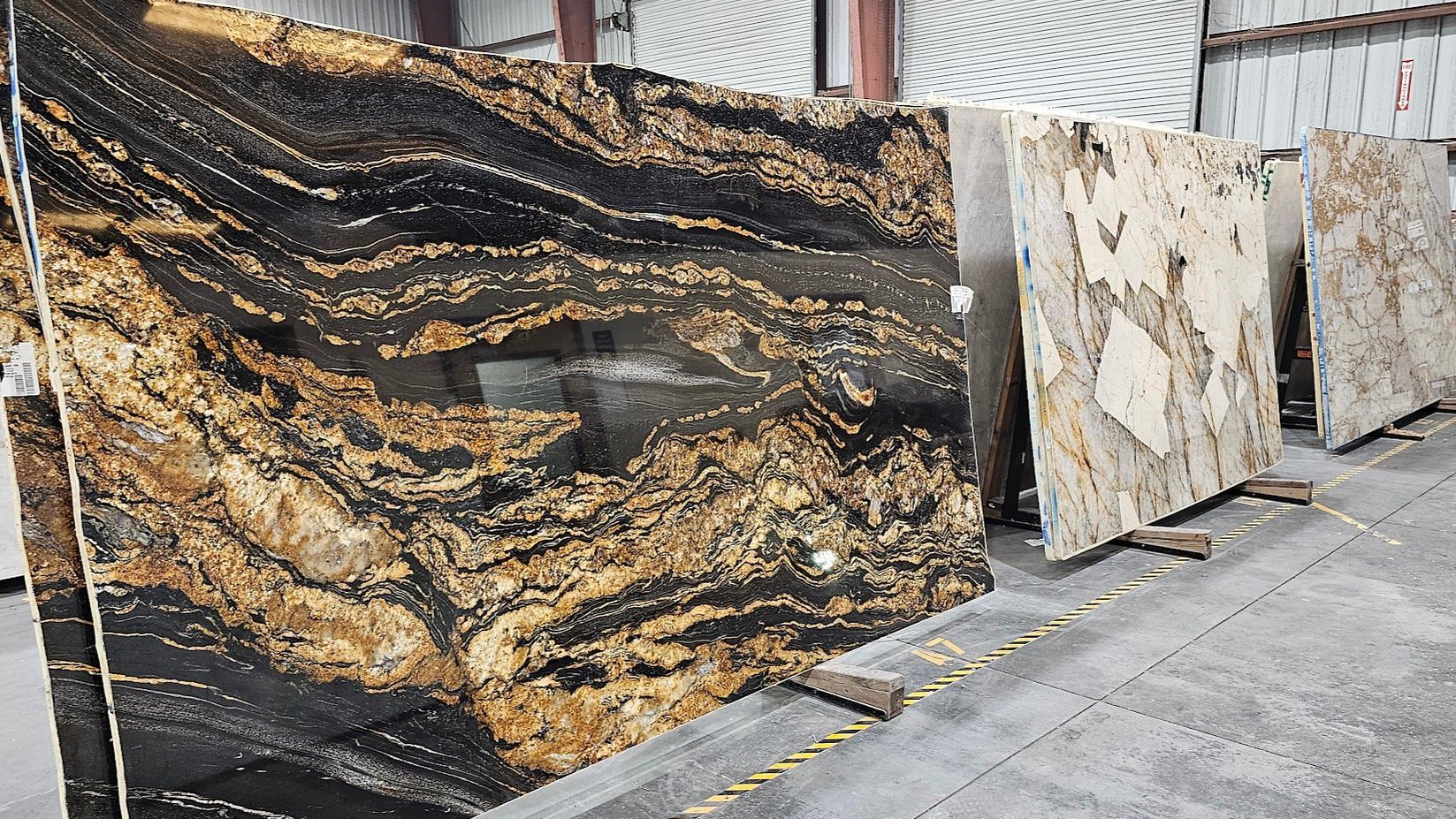 A row of granite slabs sitting on top of each other in a warehouse.