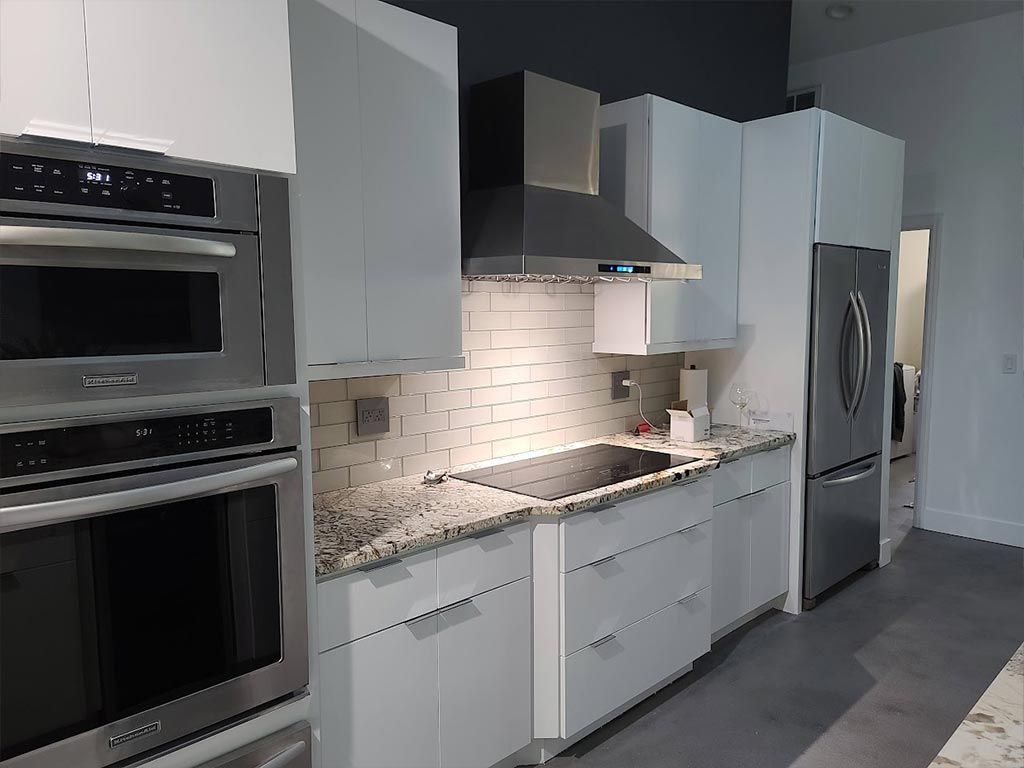 A kitchen with white cabinets and stainless steel appliances.