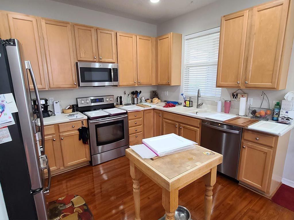 A kitchen with stainless steel appliances and wooden cabinets.