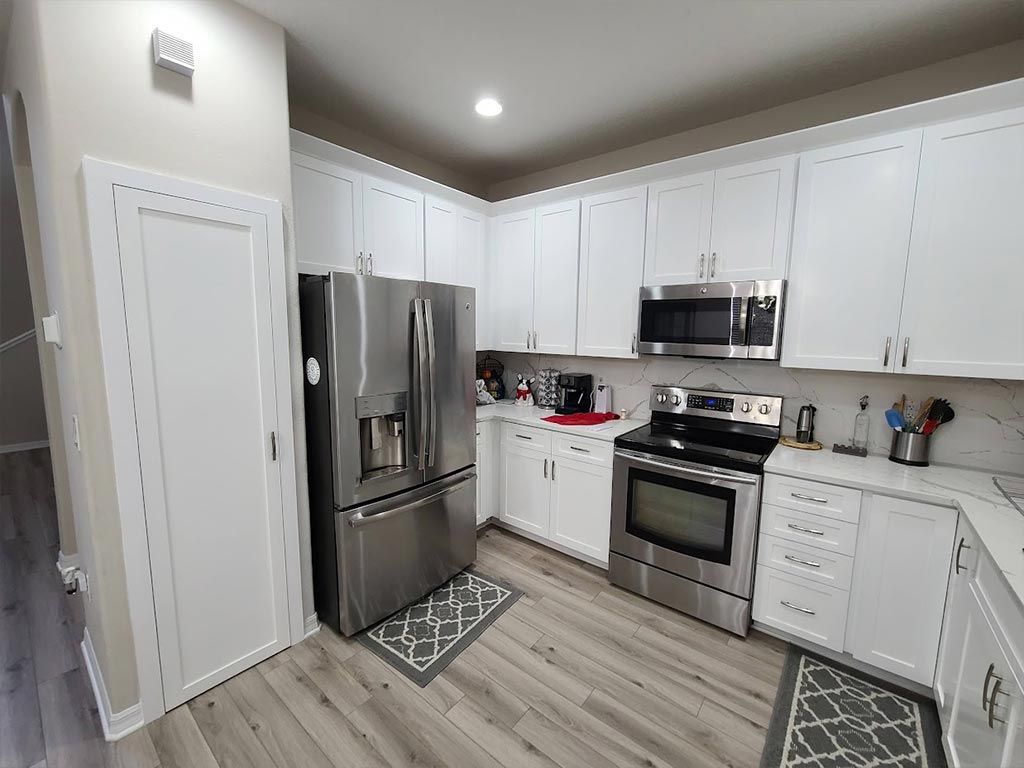 A kitchen with white cabinets and stainless steel appliances.