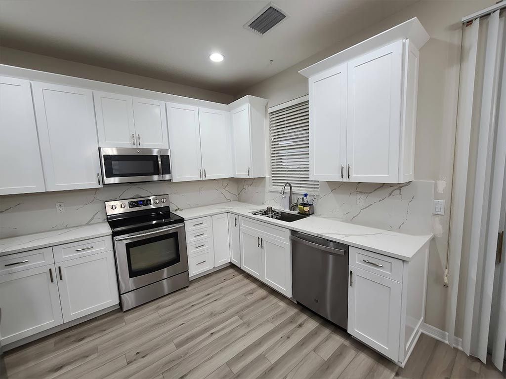 A kitchen with white cabinets and stainless steel appliances.
