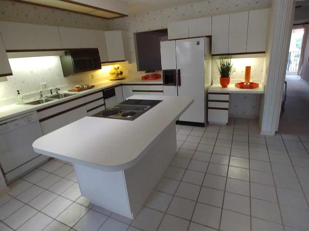 A kitchen with white cabinets and a large island in the middle