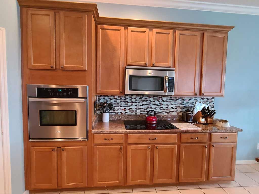 A kitchen with wooden cabinets and stainless steel appliances