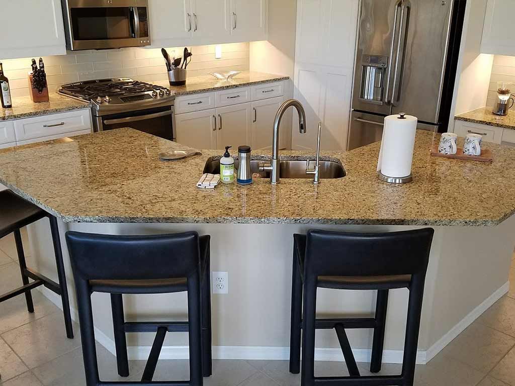 A kitchen with granite counter tops and stools