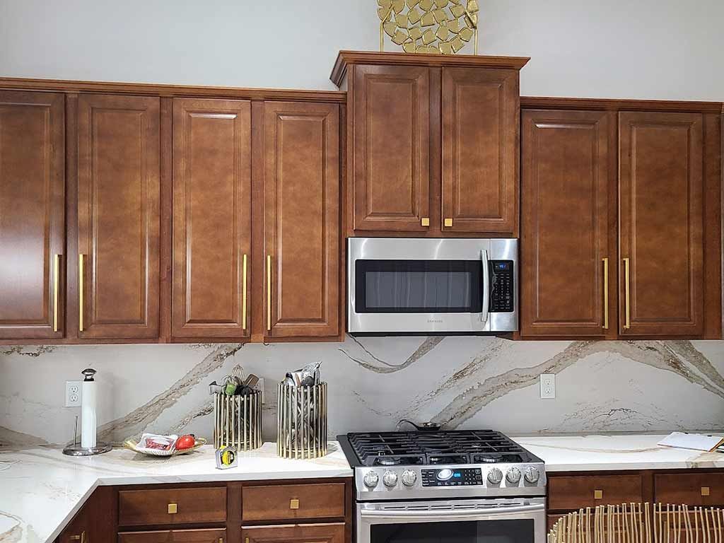 A kitchen with wooden cabinets , stainless steel appliances , and a microwave.