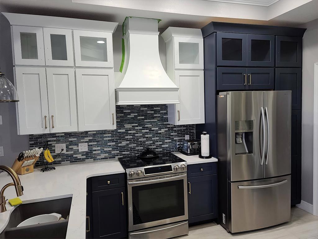 A kitchen with stainless steel appliances and blue cabinets.
