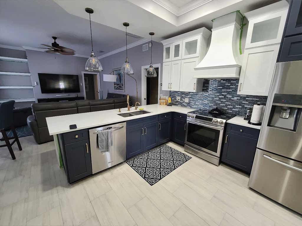 A kitchen with stainless steel appliances and blue cabinets.
