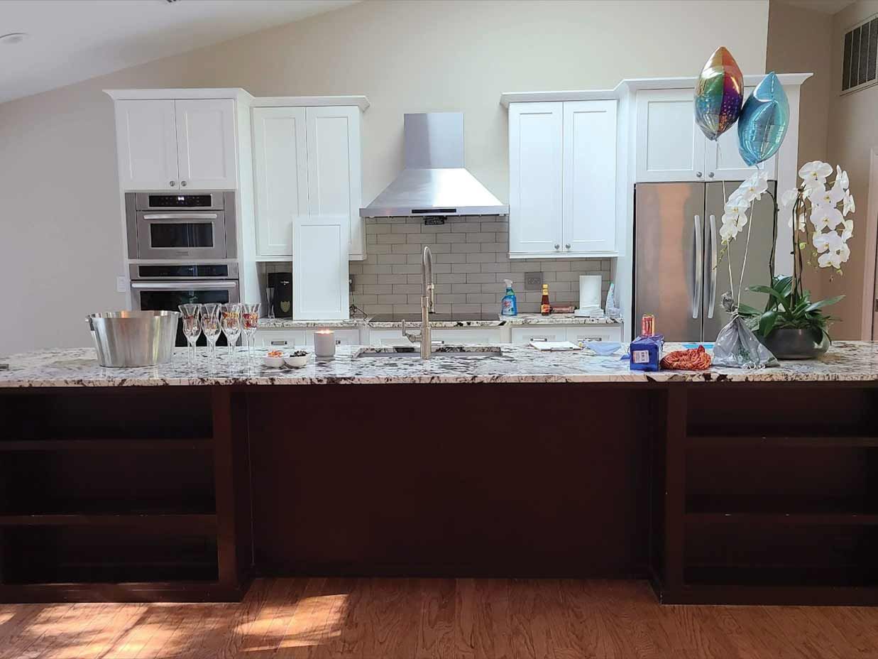 A kitchen with white cabinets and granite counter tops