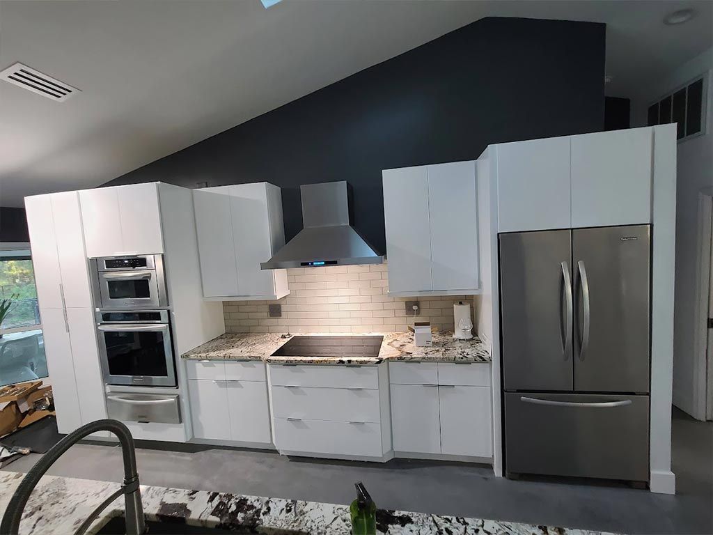 A kitchen with white cabinets and stainless steel appliances.