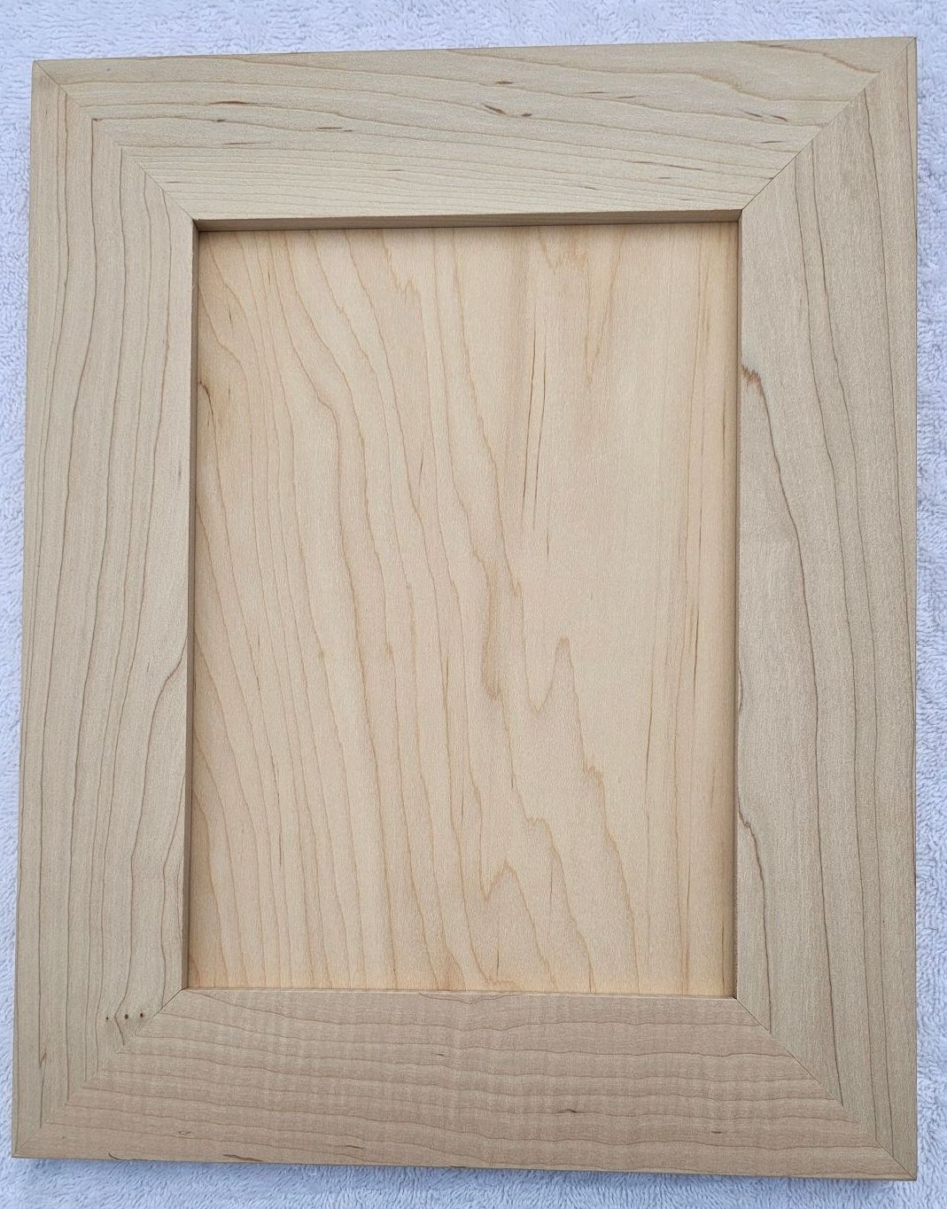 A kitchen with white cabinets , a sink , and a window.
