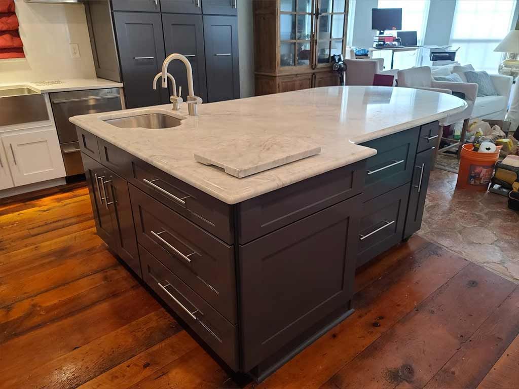 A kitchen with a large island and a sink.