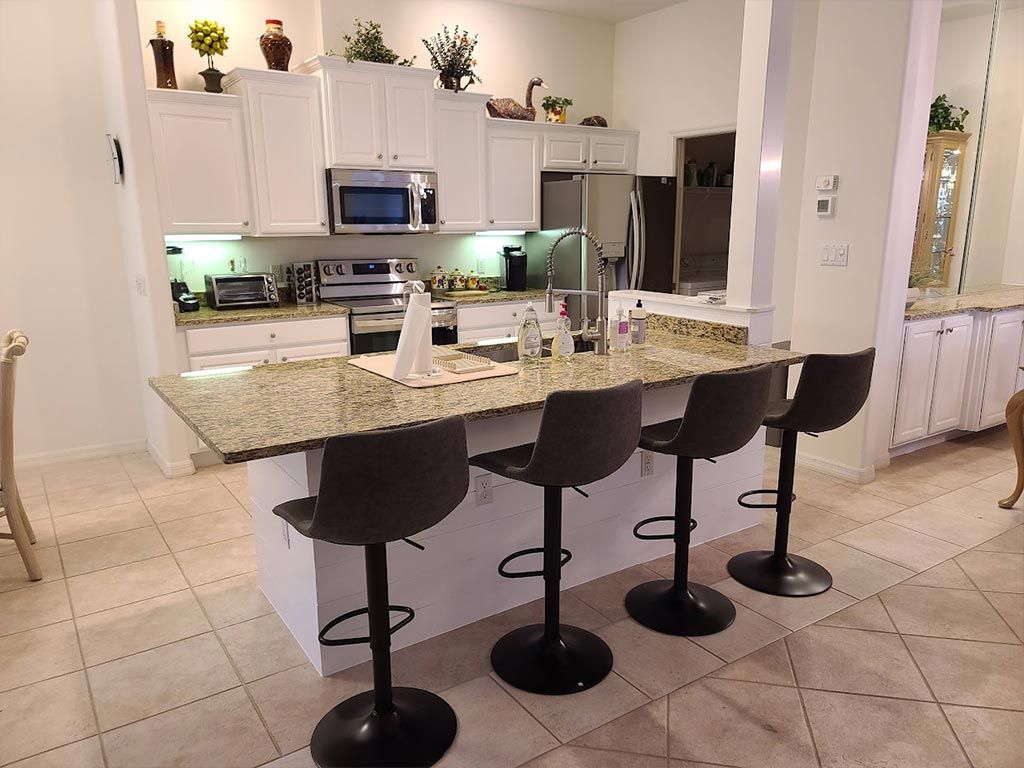 A kitchen with white cabinets and granite counter tops
