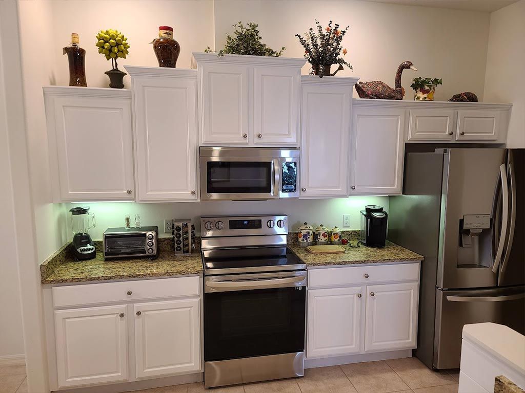 A kitchen with white cabinets and stainless steel appliances