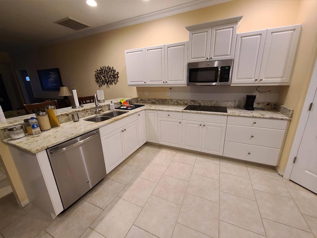 A kitchen with white cabinets and stainless steel appliances.