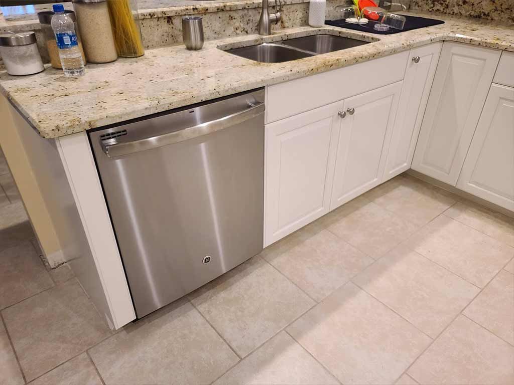 A kitchen with a stainless steel dishwasher and a sink.