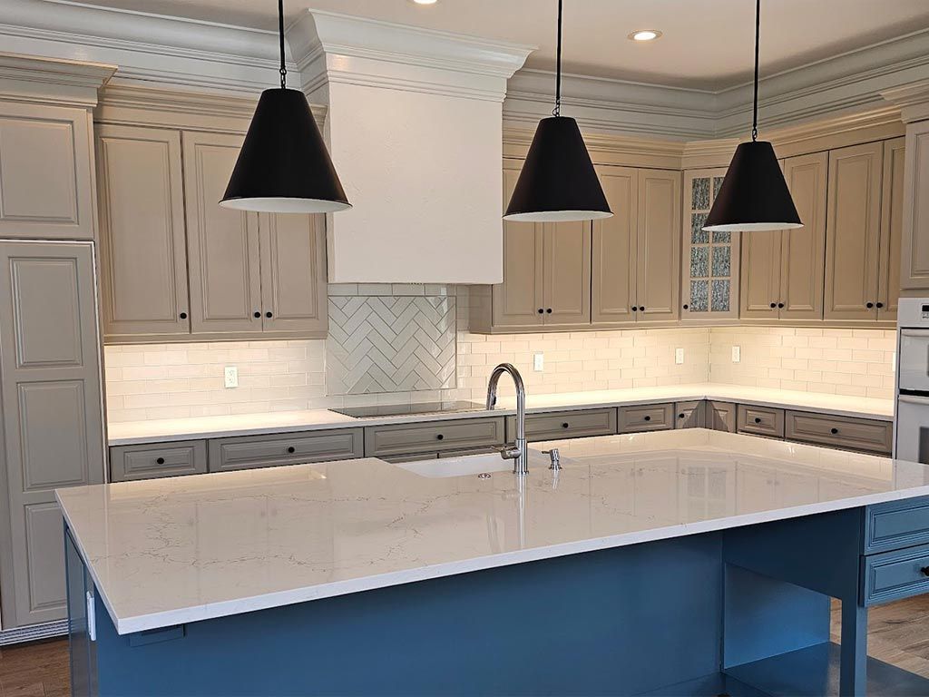 A kitchen with a large island and white counter tops