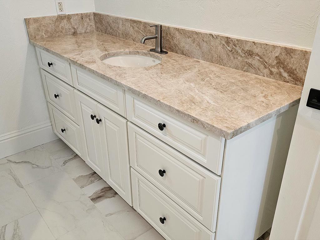 A bathroom vanity with two sinks and a granite counter top.