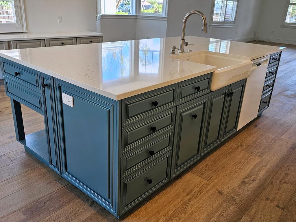 A kitchen with a large island and two sinks.