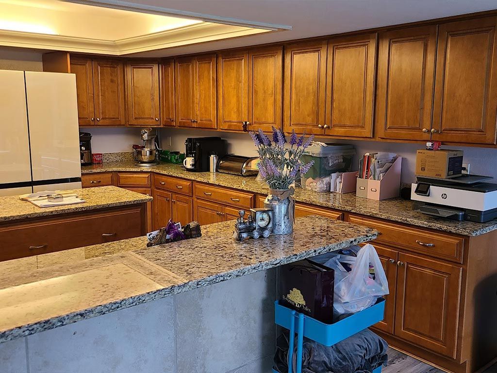 A kitchen with wooden cabinets and granite counter tops.