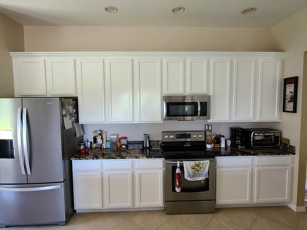 A kitchen with white cabinets and stainless steel appliances.