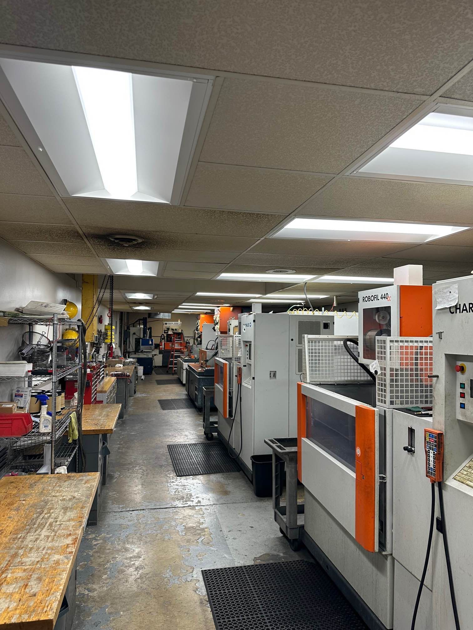 Machine shop interior with multiple industrial machines and workbenches.