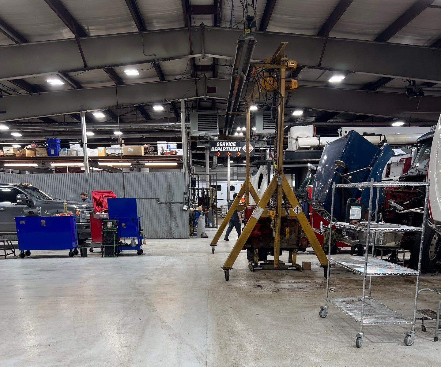 Yellow school buses inside a large garage; a person walks between them.