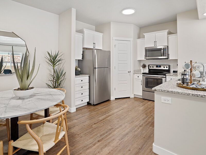 Bright kitchen in an apartment with stainless steel appliances and white cabinets.