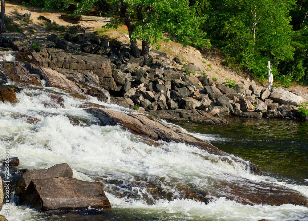 A waterfall is surrounded by rocks and trees in the middle of a forest.