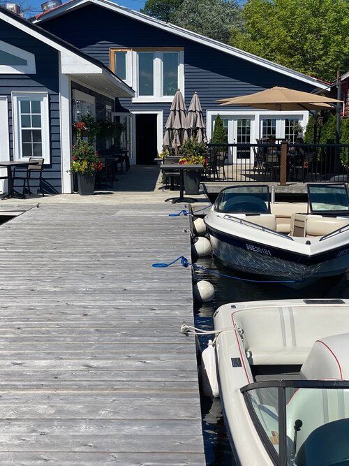 A boat is docked at a dock in front of a house.