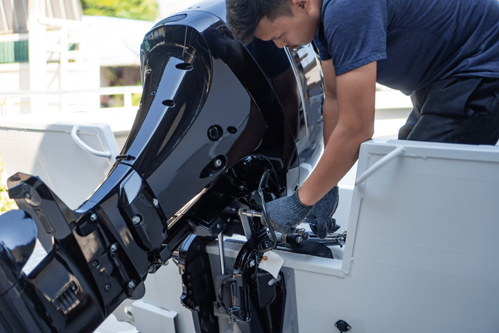 A man is working on the engine of a boat.