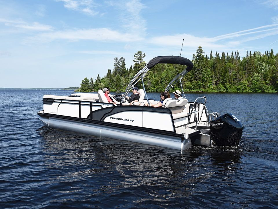 A pontoon boat is floating on top of a lake.