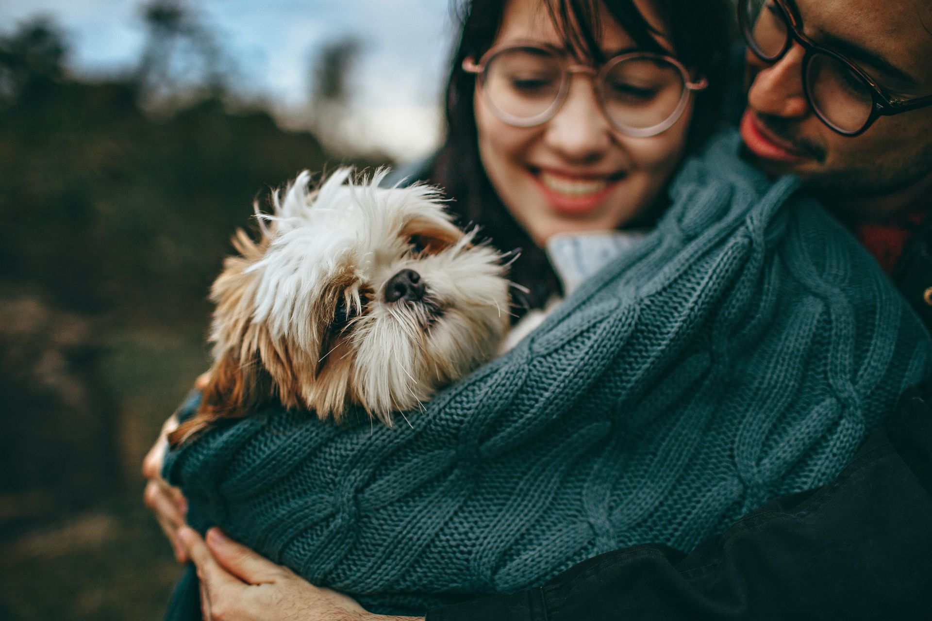 Due persone che abbracciano un cane