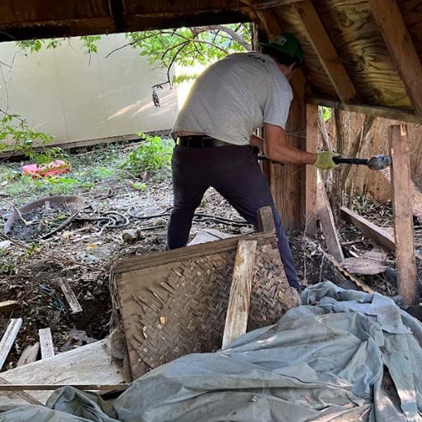 a man is working on a wooden structure with a hammer