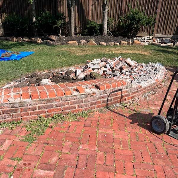 a brick wall is being demolished in a backyard
