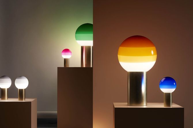 Lampade da tavolo con paralumi a globo colorati su piedistalli, in una composizione moderna.