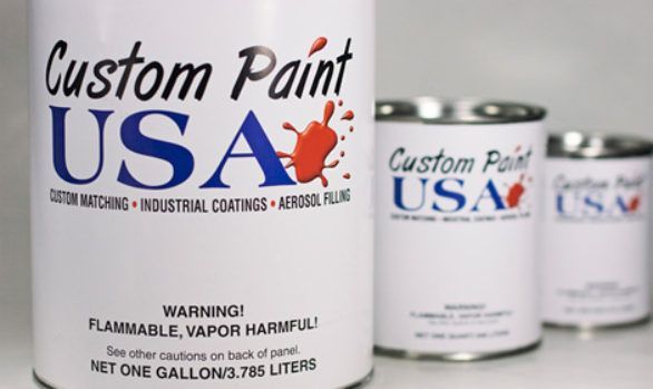 Three cans of custom paint usa sit on a table