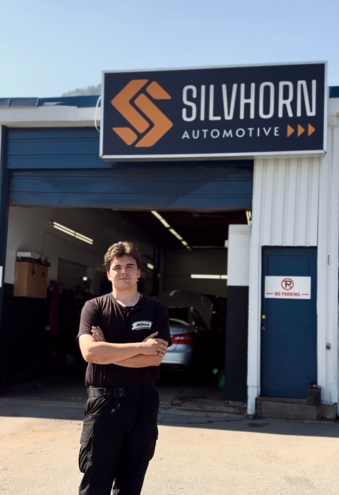 Marcus, Mike's Son, standing outside the auto shop