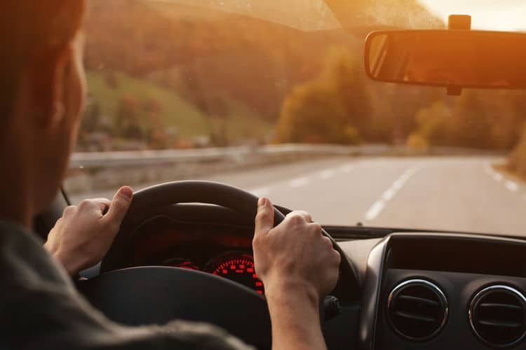 A person is driving a car down a road at sunset. | Silvhorn Automotive