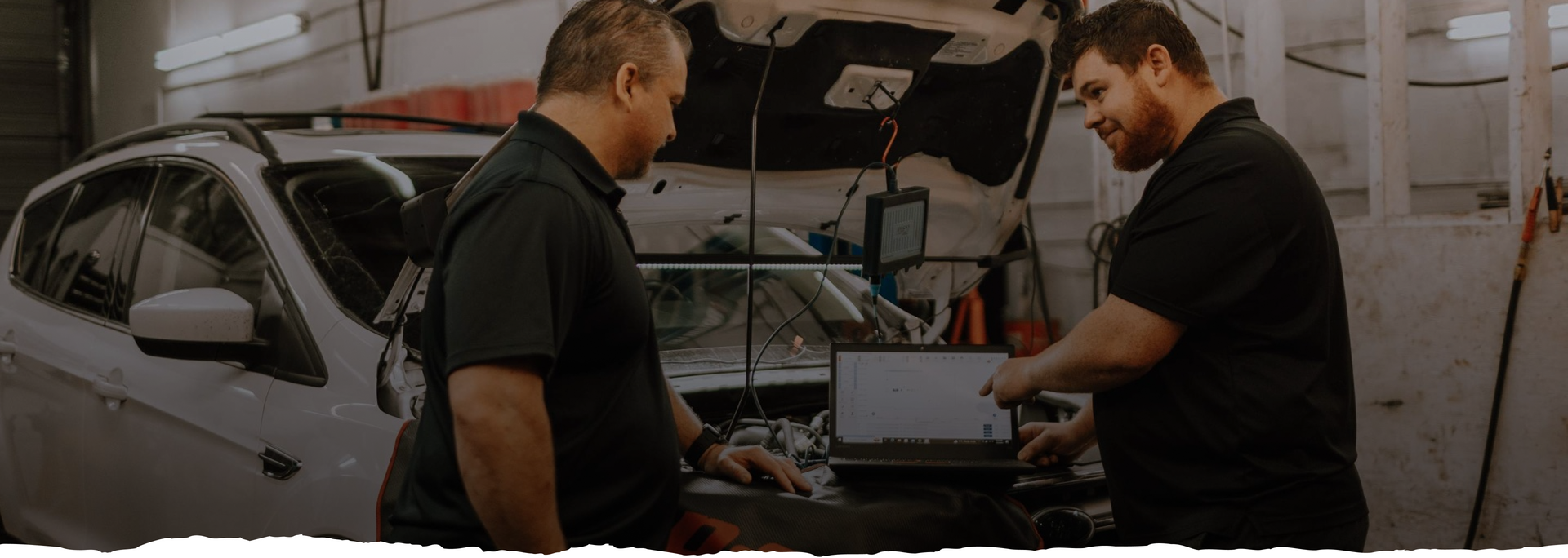 Two men are working on a car in a garage. | Silvhorn Automotive