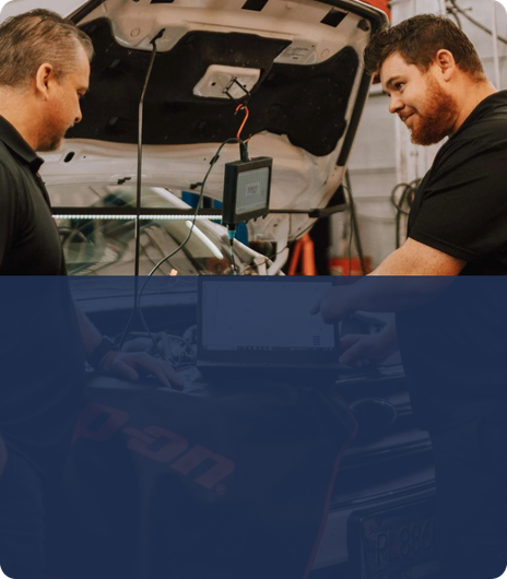 Two men are working on a car in a garage. | Silvhorn Automotive